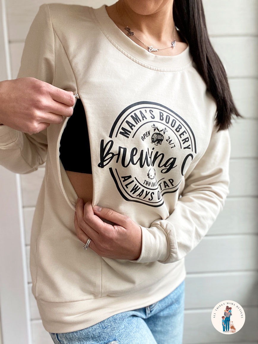 Women wearing a beige crewneck sweatshirt with a design logo Mama&